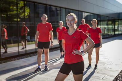 A group of employees in sportswear smiles for the camera.