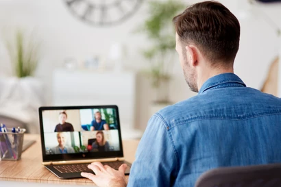 Ein Mitarbeiter arbeitet im Home office. Man sieht den Bildschirm sowie den Mitarbeiter von hinten. Ein Mitarbeiter arbeitet im Home office. Man sieht den Bildschirm sowie den Mitarbeiter von hinten.