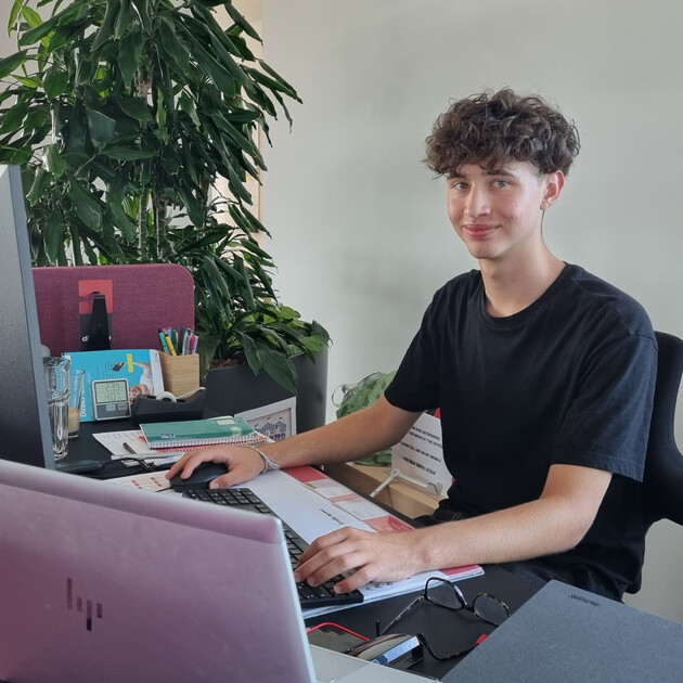 © Praktikant arbeitet am Computer im Büro.