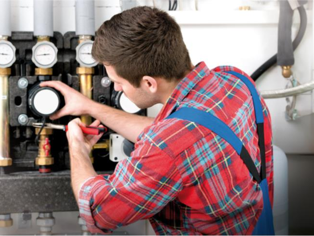 Ein junger Mann arbeitet an an einem technischen Gerät. 