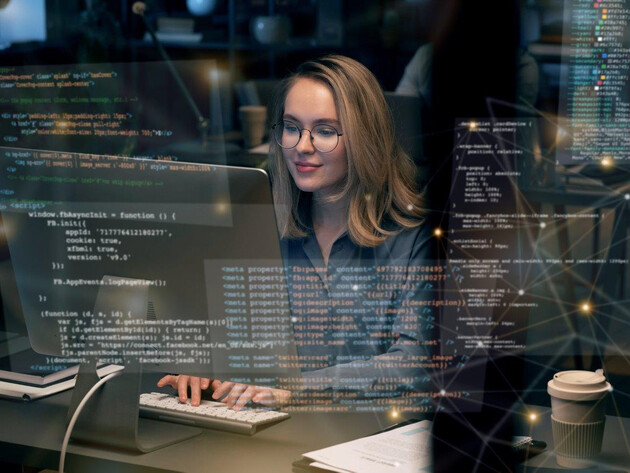 Eine Frau arbeitet an ihrem Computer und gibt verschiedene Programmiercodes ein.