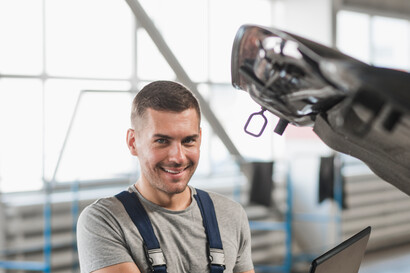 An apprentice operates a machine in the workshop.