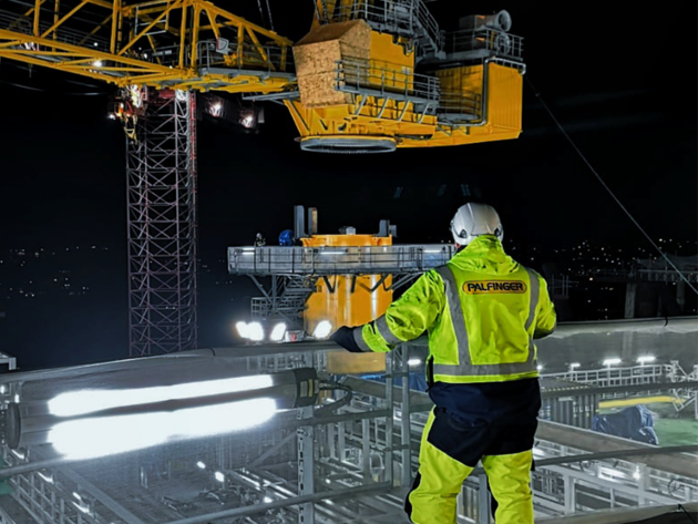 PALFINGER MARINE service engineer watching at a wire luffing lattice boom crane during assembly