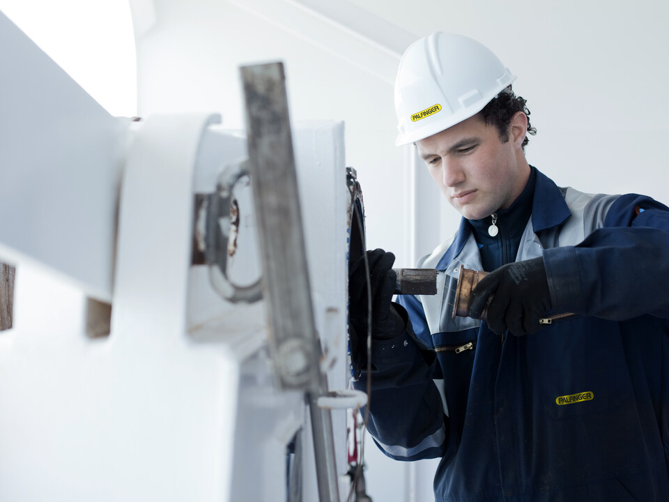 A MARINE servicetechnician is working on a marine crane